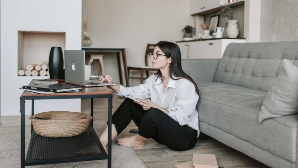 Woman Sitting On The Floor While Using Her Laptop
